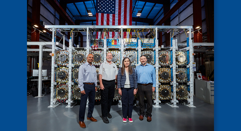 Four people celebrate the next milestone for the Scorpius accelerator