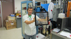 Zachary Seeley holds a gadolinium–lutetium–oxide (GLO) transparent ceramic scintillator plate.