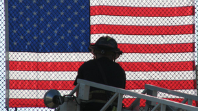 Firefighter attaching American flag to fencing